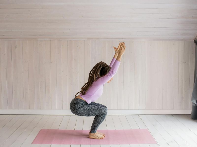 Person practicing yoga in a modern dark room.