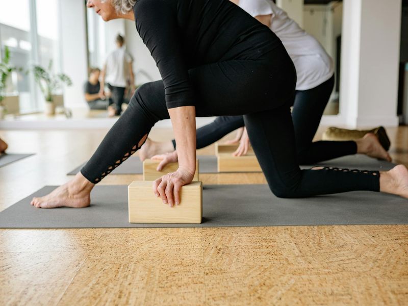 Yoga mat and blocks in a sunlit studio space.